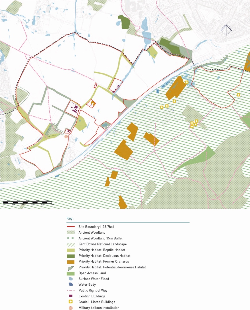 Map showing a 133.7-hectare site boundary in red, surrounded by ancient woodland with a 15-meter buffer, and the Kent Downs National Landscape. Priority habitats include reptile, decicuous, former orchards, and potential dormouse habitats, marked in various shades of green and brown. Open access land, surface water flood zones, water bodies, public rights of way, existing buildings, and Grade II listed buildings are also indicated. Military balloon installation marked with an orange balloon icon.